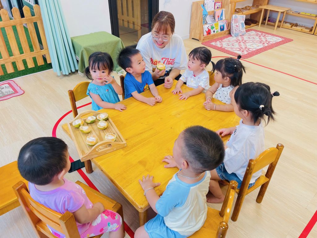 Đôi tay bé 2 tuổi lớp Sky tập trung bóc vỏ cam trong giờ Thực hành cuộc sống tại Mầm Non Sunflower Đông Hưng Thuận